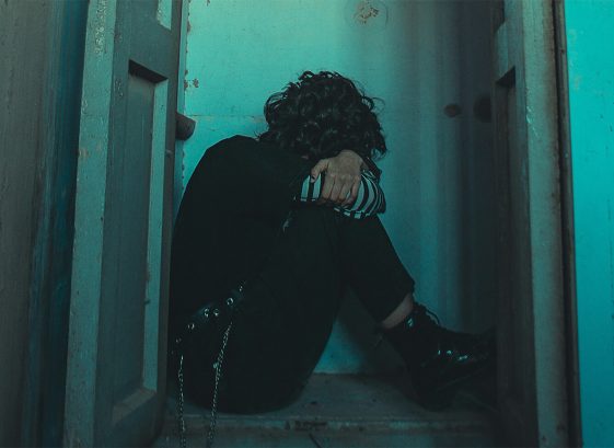 man head in hands in doorway